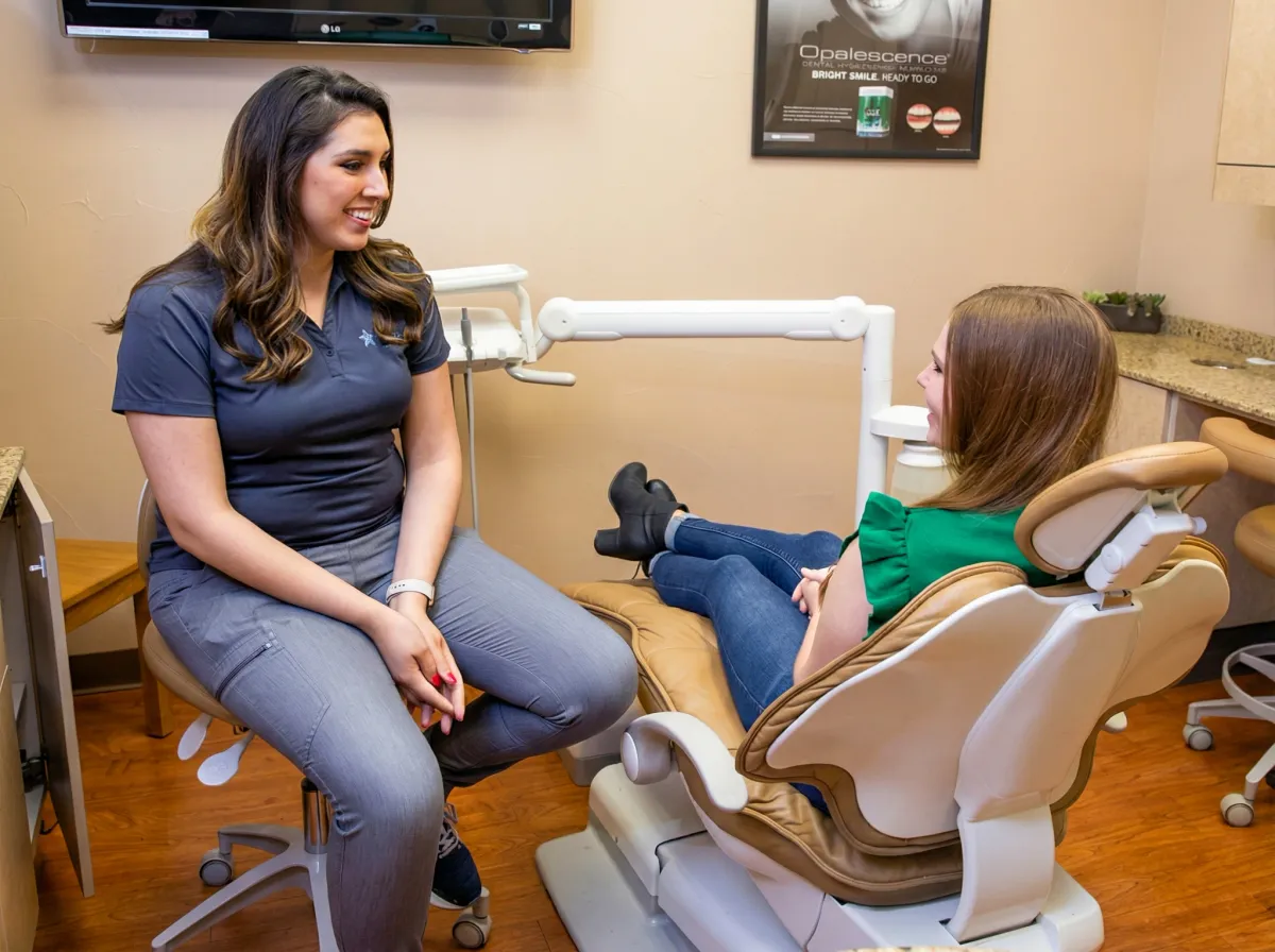 Team member chatting with a patient in the treatment chair